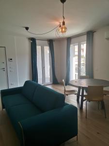 ein Wohnzimmer mit einem blauen Sofa und einem Tisch in der Unterkunft B&B PORTELLO Le Terrazze 2 in Mailand