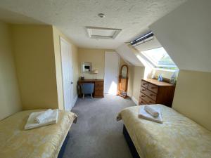 a bedroom with two beds and a desk and a window at New Forest View in Beaulieu