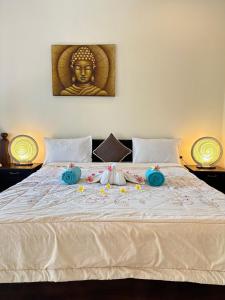 una cama con una estatua de un buddha en ella en Sanshikirana House Lovina, en Lovina