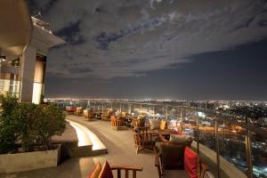 a restaurant balcony with a view of a city at night at OV Residence in Bangkok