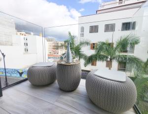 a balcony with two stools and a view of a building at Los Cristianos Ljus in Arona