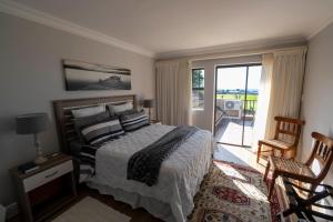 a bedroom with a bed and a balcony at Fairways Apartment Mossel Bay Golf Estate in Mossel Bay