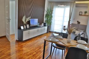 Praga Premium Comfort في وارسو: غرفة معيشة مع طاولة طعام وتلفزيون
