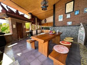 a kitchen with a table and benches in a room at Sanshikirana House Lovina in Lovina