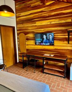 a living room with a tv on a wooden wall at Pousada Casa Paradiso Guarujá in Guarujá