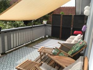 eine Terrasse mit einem Tisch und Stühlen auf dem Balkon in der Unterkunft Schöne Ferienwohnung im Voralpenland in Pfaffing