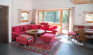 un soggiorno con un divano rosso e un tavolo di Holiday flat Val di Lai with Jacuzzi for 6 persons-Lenzerheide a Lenzerheide