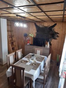 a dining room with a table and a tv at Domek w górach Wioletta in Rycerka Górna
