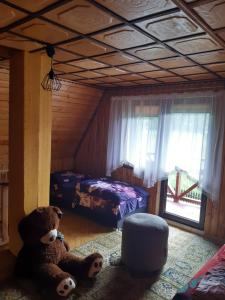 un dormitorio con un osito de peluche sentado en el suelo en Domek w górach Wioletta, en Rycerka Górna