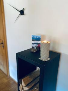 eine Kerze auf einem schwarzen Tisch mit einer Uhr in der Unterkunft Mountain Getaway Sedrun in Rueras