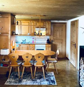 a kitchen with a wooden table and chairs at Mountain Getaway Sedrun in Rueras +34 photos