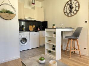 a kitchen with a washing machine and a table and a chair at Le Sablier - Centre ville - 15 min du Futuroscope in Poitiers