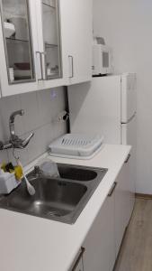 a white kitchen with a sink and a microwave at metro La Salut in Badalona