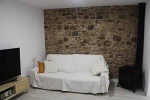 a white couch in a room with a brick wall at Casa Remes in Sagunto
