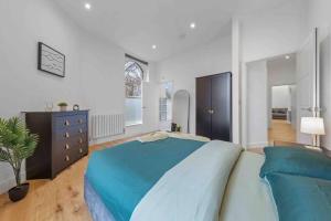 a large bedroom with a blue bed and a dresser at 2BR flat for 6 in Central London LR2 in London