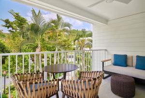 a balcony with a table and two chairs and a couch at Morningstar Buoy Haus Beach Resort at Frenchman's Reef, Autograph Collection in Nazareth
