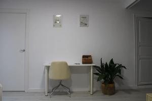 einen Schreibtisch mit einem Stuhl und einer Pflanze in einem Zimmer in der Unterkunft Casa Remes in Sagunt