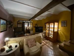 uma sala de estar com um sofá branco e uma televisão em Casa Rural el Zapatero 