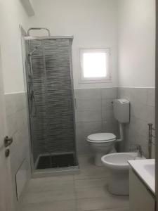a bathroom with a shower and a toilet and a window at 2 bedrooms apartement at Sciacca 400 m away from the beach with sea view furnished garden and wifi in Sciacca