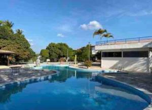 a swimming pool with blue water and a building at Chalé Refidim in Gravatá