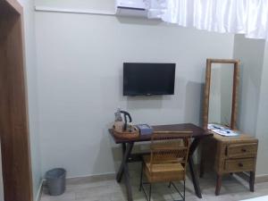 Zimmer mit einem Schreibtisch, einem TV und einem Stuhl in der Unterkunft KAWETA COTTAGE in Yadinga