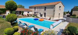 una piscina en el patio trasero de una casa en A la Gloriette, en Neuville-du-Poitou