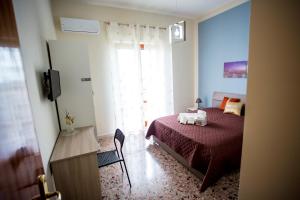 um quarto com uma cama, uma televisão e uma janela em B&B L'Aurora CAPUA em Capua