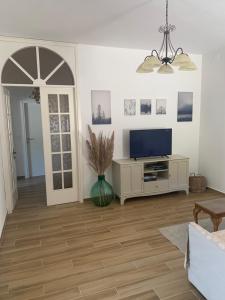 ein Wohnzimmer mit einem TV und einem Tisch in der Unterkunft Valdonica - Relax in campagna in La Spezia