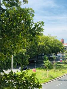 Blick auf einen Parkplatz mit Bäumen und eine Straße in der Unterkunft Cozy Apartment in Hannover Central in Hannover