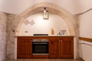 eine Küche mit einer Theke und einem Torbogen in der Unterkunft Trullo vacanze di Cummà Rosa in Alberobello