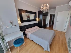 een slaapkamer met een bed, een spiegel en een stoel bij Anastasia's boutique apartment in Cattolica