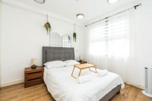 a bedroom with a bed with a table on it at Amazing 2 bedroom / Earls Court / Kensington in London