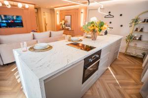 cocina con encimera y sala de estar. en Pink Perfection - One-Bedroom Gemstone Oasis, en Bucarest