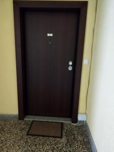 eine braune Tür mit einer Matte davor in der Unterkunft Apartman Sandi in Novi Travnik