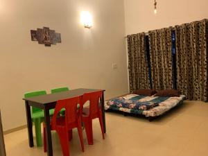 Cette chambre comprend une table, des chaises et un lit. dans l'établissement Chalet Ahaz, the place of privacy with outside sitting, à Karjat