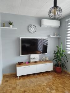 sala de estar con TV de pantalla plana en una pared blanca en Apartman Sandi, en Novi Travnik