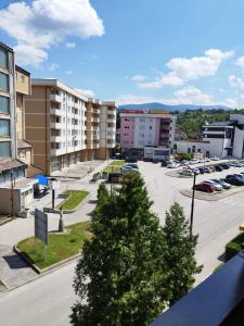 eine Stadtstraße mit Gebäuden und einem Parkplatz in der Unterkunft Apartman Sandi in Novi Travnik