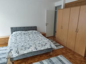 a bedroom with a bed and wooden cabinets at Apartman Sandi in Novi Travnik