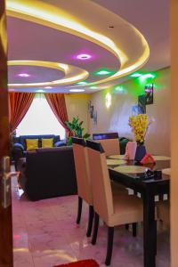 Milimani Apartment Comfy Homestay في ناكورو: غرفة طعام مع طاولة وأريكة