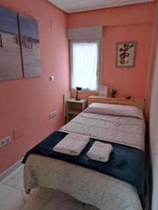 sypialnia z 2 łóżkami i oknem z ręcznikami w obiekcie Apartamento Zona Playa y centro Ciudad w mieście Santander