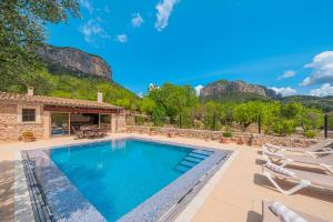 a swimming pool with chairs and a house at Sa Sort in Alaró