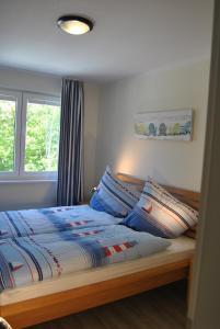 Schlafzimmer mit einem Bett und einem Fenster in der Unterkunft Ferienwohnung Blaubärstrand in Juliusruh