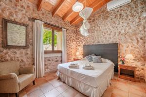 a bedroom with a bed and a chair and a window at Sa Sort in Alaró +22 photos