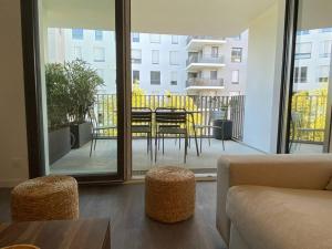 - un salon avec un balcon doté d'une table et de chaises dans l'établissement Appartement cosy 80m2 au pied du tram de Bordeaux, à Eysines