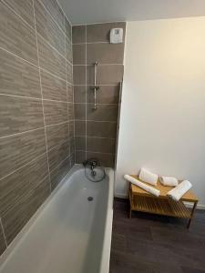 La salle de bains est pourvue d'une baignoire, d'une douche et de serviettes. dans l'établissement Appartement cosy 80m2 au pied du tram de Bordeaux, à Eysines