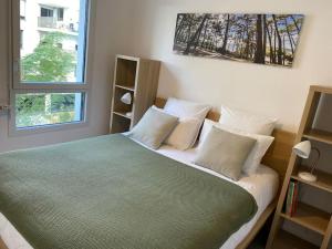 - une chambre avec un lit doté d'oreillers blancs et d'une fenêtre dans l'établissement Appartement cosy 80m2 au pied du tram de Bordeaux, à Eysines