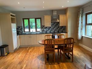 cocina con mesa de madera y sillas en Creevagh Cottage, en Castlebar