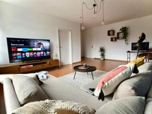Große Wohnung im Zentrum von Osnabrück في أوسنابروك: غرفة معيشة مع أريكة وتلفزيون بشاشة مسطحة