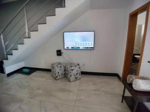 a living room with a staircase with a flat screen tv at Casa confortável e segura na região da Pampulha in Belo Horizonte