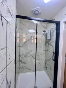 een douche met een glazen deur in de badkamer bij City Studio Apartment Swansea - Includes Free Parking in Swansea